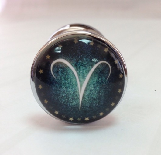 Серебристая анальная пробка с зеленым кристаллом и знаком зодиака - Овен - Главсексмаг - купить с доставкой в Новосибирске